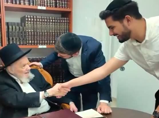 רב לוחץ את יד הבוחר