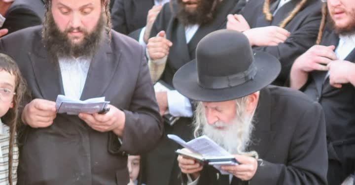 חסידים מתפללים בספרי תפילה