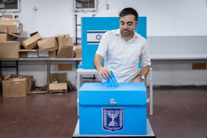 אדם משלשל פתק הצבעה לקלפי