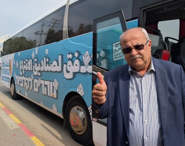 חבר כנסת לצד אוטובוס קמפיין הבחירות
